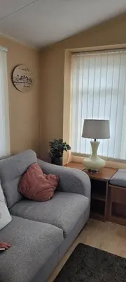 a living room with a couch and a table with a lamp at Willerby Delux - Holiday Home by the Sea - close to the Entertainment Complex-bedding, towels & wifi Included! in Jaywick Sands