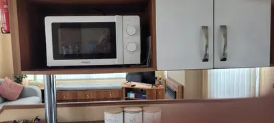 a microwave sitting on a shelf in a living room at Willerby Delux - Holiday Home by the Sea - close to the Entertainment Complex-bedding, towels & wifi Included! in Jaywick Sands