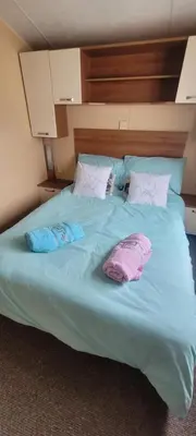 a bed with two pillows and two towels on it at Willerby Delux - Holiday Home by the Sea - close to the Entertainment Complex-bedding, towels & wifi Included! in Jaywick Sands