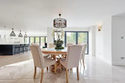 a kitchen and dining room with a wooden table and chairs at Mayrose House - 6BR 4BATH Luxe Spacious Retreat in Takeley