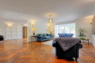 a living room with a bed and a couch at Mayrose House - 6BR 4BATH Luxe Spacious Retreat in Takeley