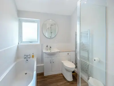 a bathroom with a tub and a toilet and a sink at Mals Barn in Althorne