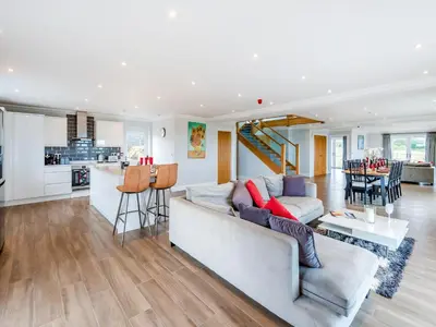 a living room with a couch and a kitchen at Mals Barn in Althorne