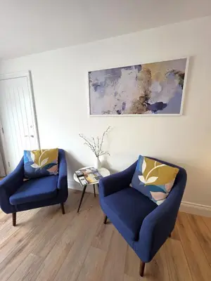 two chairs and a table in a living room at Modern One Bed Flat at Dawe Luxury Suites - An Entire Apartment near Ely Cathedral & Train Station - The Perfect Gateway to Explore Ely, Cambridge, Norfolk & London - Sleeps up to 4 in Ely