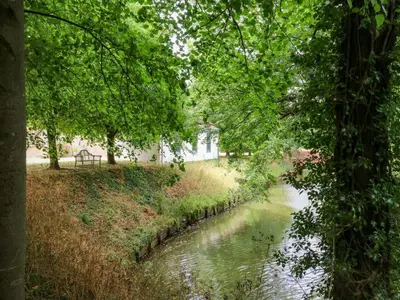 a river with a house in the background at Clock Tower in Stowmarket