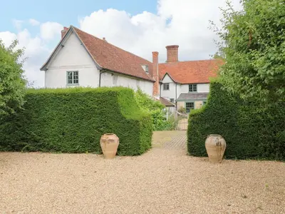 two vases in front of a hedge in front of a house at Clock Tower in Stowmarket
