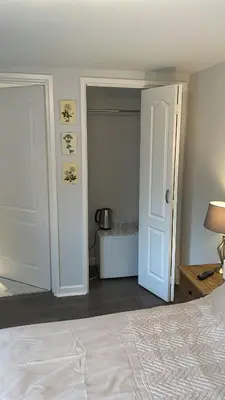 a bedroom with a bed and an open door at Latchmead in Little Hallingbury