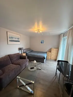 a living room with a couch and a bed at Latchmead in Little Hallingbury