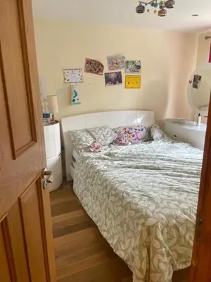 a bedroom with a bed and a bathroom with a sink at Konesha in Loughton