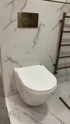 a white toilet in a bathroom with marble walls at Konesha in Loughton