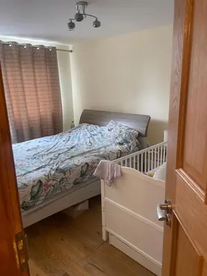 a small bedroom with a bed and a crib at Konesha in Loughton