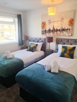 two beds sitting next to each other in a room at Chelmsford Getaway Business and Leisure