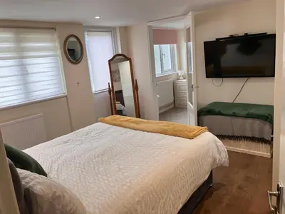 a bedroom with a bed and a flat screen tv at The Cosy Annexe in Wymondham