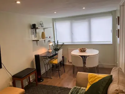 a living room with a couch and a table and a window at The Cosy Annexe in Wymondham