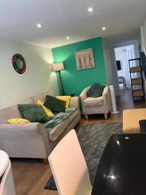 a living room with a couch and a chair at The Cosy Annexe in Wymondham