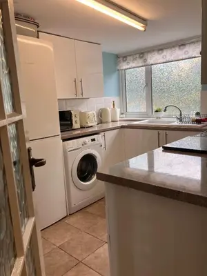 a kitchen with a washing machine and a washer at The Cosy Annexe in Wymondham