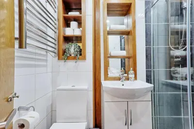 a white bathroom with a sink and a shower at Quirky 2-Bed Brentwood Home Near High St & Station - With Parking in Brentwood