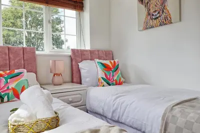 a bedroom with two beds and a window at Quirky 2-Bed Brentwood Home Near High St & Station - With Parking in Brentwood