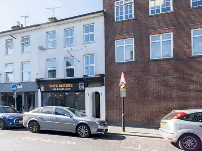two cars parked in front of a brick building at Cosy flat in the heart of Southend Pass The Keys in Southend-on-Sea