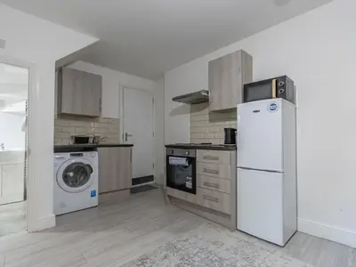 a kitchen with a refrigerator and a washer and dryer at Cosy flat in the heart of Southend Pass The Keys in Southend-on-Sea