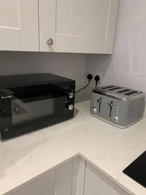 a microwave sitting on a counter next to a toaster oven at The Annexe Westbury House in Great Dunmow