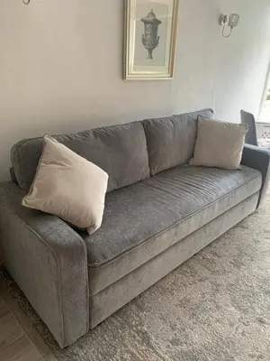 a gray couch with two pillows on it in a room at The Annexe Westbury House in Great Dunmow
