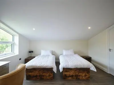 a bedroom with two beds with white sheets and a window at Whiskey Barns in Birch