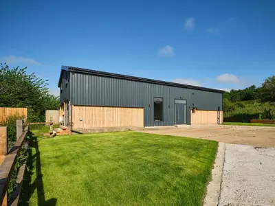a large building with a grass yard in front of it at Whiskey Barns in Birch