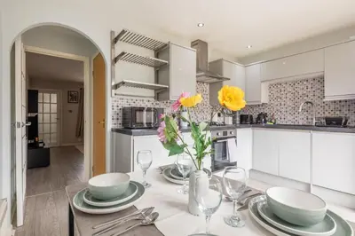 a kitchen with a table with plates and flowers on it at Stylish 2-Bed Home in Cambridge in Cambridge