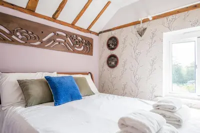 a bedroom with a white bed with towels on it at Farm View suite, Kelsale in Kelsale