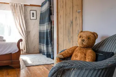 a teddy bear sitting in a chair in a room at Farm View suite, Kelsale in Kelsale