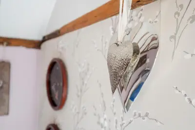 a heart hanging on a wall with a clock at Farm View suite, Kelsale in Kelsale