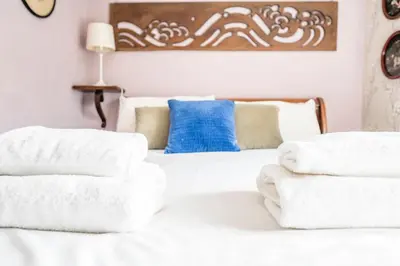 a bedroom with a white bed with towels on it at Farm View suite, Kelsale in Kelsale