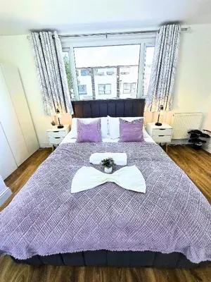 a purple bed with a tray on top of it at Hertfordshire - Stylish 6BR Retreat, 3 Parking in Stevenage