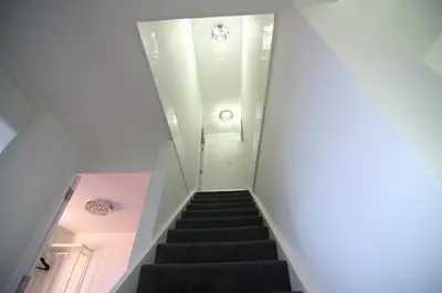 a staircase in a house with a pink light at Hertfordshire - Stylish 6BR Retreat, 3 Parking in Stevenage