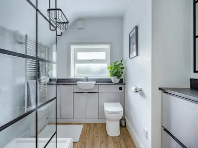 a bathroom with a toilet and a sink and a window at Oak Tree Cottage in Kirby Cross