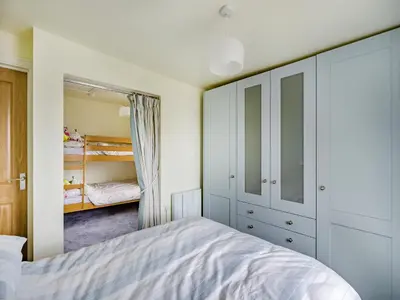 a bedroom with a bed and a closet at Oak Tree Cottage in Kirby Cross