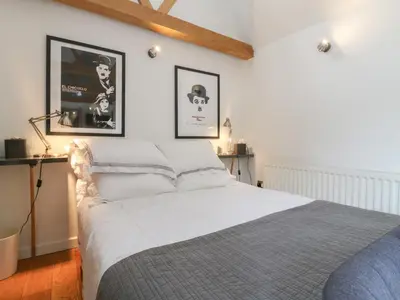 a bedroom with a bed with two pictures on the wall at Little Barn in Royston