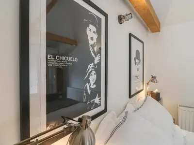 a large picture hanging on a wall above a bed at Little Barn in Royston