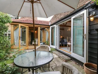 a table with an umbrella on a patio at Little Barn in Royston