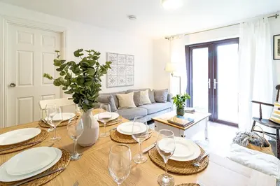 a living room with a table and a couch at Large 6-BDR House in Cambridge in Barnwell Junction Station
