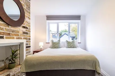 a bedroom with a bed and a brick wall at Large 6-BDR House in Cambridge in Barnwell Junction Station