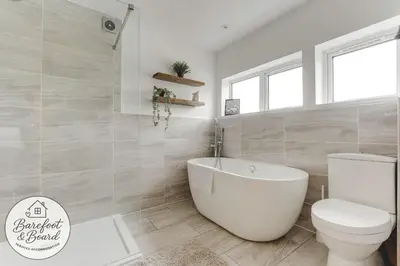 a bathroom with a white tub and a toilet at Luxury 2-Bed House in Stevenage Sleeps 6 Free Parking Barefoot & Board in Shephall