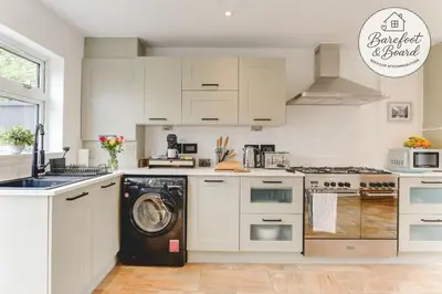 a white kitchen with a washing machine in it at Luxury 2-Bed House in Stevenage Sleeps 6 Free Parking Barefoot & Board in Shephall