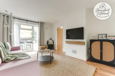 a living room with a couch and a tv at Luxury 2-Bed House in Stevenage Sleeps 6 Free Parking Barefoot & Board in Shephall