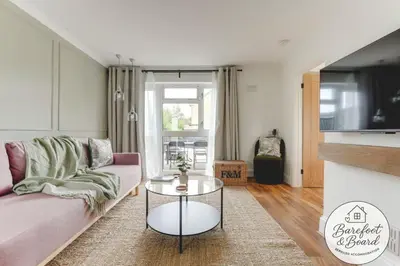 a living room with a couch and a table at Luxury 2-Bed House in Stevenage Sleeps 6 Free Parking Barefoot & Board in Shephall