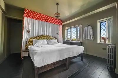 a bedroom with a large bed with a red headboard at Finest Retreats - ARC Thorpeness in Thorpeness