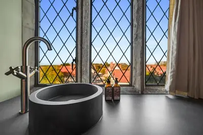 a bathroom with a bath tub in front of a window at Finest Retreats - ARC Thorpeness in Thorpeness