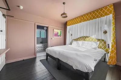 a bedroom with a large bed with a yellow headboard at Finest Retreats - ARC Thorpeness in Thorpeness