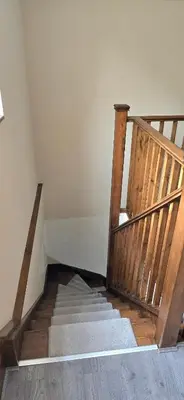 a staircase with wooden railings in a room at Charming Coach House Cottage in Brentwood in Kelvedon Hatch